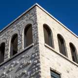 Chiude il prospetto un cornicione sorretto da mensole e un torrino con loggia ad archi che reinterpreta le forme classiche e romaniche